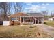 Charming brick home featuring a covered front porch, gray roof, and a well-maintained front yard at 74 Azalea Dr, Roxboro, NC 27573