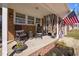 Inviting front porch with rocking chairs, an American flag, and privacy curtains at 74 Azalea Dr, Roxboro, NC 27573