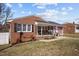 Charming brick home with black shutters, an American flag, and a welcoming front porch at 74 Azalea Dr, Roxboro, NC 27573