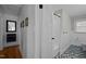 Hallway adjacent to bathroom with hardwood floors, wainscoting, and access to the tiled shower and toilet at 74 Azalea Dr, Roxboro, NC 27573
