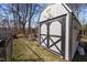 Charming storage shed with black and white accents, ladder, and firepit area nearby at 74 Azalea Dr, Roxboro, NC 27573