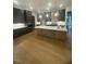 Spacious kitchen with dark cabinets, a large island, and pendant lighting above wood floors at 80 Valebrook Ct, Youngsville, NC 27596