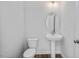 Stylish half-bath with sleek vanity, oval mirror, contemporary fixtures, and a streamlined toilet at 82 Fairwinds Dr, Lillington, NC 27546