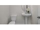 Neutral bathroom with pedestal sink, oval mirror and lovely floral decor at 82 Fairwinds Dr, Lillington, NC 27546