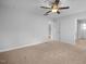 Spacious carpeted bedroom with ceiling fan, featuring multiple windows and doorways for easy access at 82 Fairwinds Dr, Lillington, NC 27546