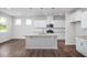 Bright kitchen with white cabinets, stainless steel appliances, and a large center island with countertop seating at 82 Fairwinds Dr, Lillington, NC 27546