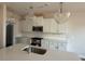Modern kitchen island with a stainless steel sink, quartz countertops, white cabinets, and pendant lights above at 82 Fairwinds Dr, Lillington, NC 27546