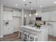 Bright kitchen features an island with seating, pendant lighting, and stainless steel appliances at 82 Fairwinds Dr, Lillington, NC 27546