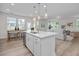 Open kitchen showcasing a large island, pendant lights, stainless sink, and flow into the living area at 82 Fairwinds Dr, Lillington, NC 27546
