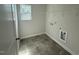 Functional laundry room with tile floors, storage shelves, and space for a washer and dryer, and a window at 82 Fairwinds Dr, Lillington, NC 27546