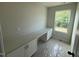 Well-lit office space with built-in cabinets, a desk, a large window, and floors are covered with construction plastic at 82 Fairwinds Dr, Lillington, NC 27546