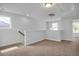 Upstairs landing with neutral carpet and views out the windows, with railing and lighting at 82 Fairwinds Dr, Lillington, NC 27546