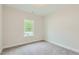 Bright bedroom featuring neutral carpet, white walls, and one window offering natural light at 936 Jasper Mine Trl, Raleigh, NC 27610
