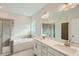 Luxurious main bathroom featuring double sink vanity, soaking tub, and glass-enclosed shower at 936 Jasper Mine Trl, Raleigh, NC 27610