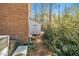 Backyard view showing the home's brick exterior, outbuilding, and natural surroundings at 100 Forsyth Dr, Chapel Hill, NC 27517