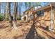 Exterior showcasing the home's brick construction, a small deck, and mature trees at 100 Forsyth Dr, Chapel Hill, NC 27517