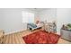 Comfortable bedroom featuring wood flooring, a cozy bed, and a desk area, with a decorative rug adding warmth at 100 Forsyth Dr, Chapel Hill, NC 27517