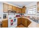 Functional kitchen featuring wood cabinets, an electric range, and a double basin sink at 100 Forsyth Dr, Chapel Hill, NC 27517