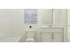 Clean, all-white bathroom featuring modern fixtures, blue art, and a shower/tub combination at 10064 Regal Dr, Angier, NC 27501