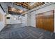 Finished basement area with a combination of black rubber and patterned carpet flooring and two large doors at 1017 Holly Creek Ln, Chapel Hill, NC 27516