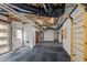 Open basement with a mix of rubber and carpet flooring, white brick walls, and a garage door at 1017 Holly Creek Ln, Chapel Hill, NC 27516