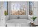 Bright bathroom features a standalone tub with large windows and view of trees at 1017 Holly Creek Ln, Chapel Hill, NC 27516