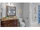 Modern bathroom features a dark vanity with granite countertop, and a white tiled tub shower at 1017 Holly Creek Ln, Chapel Hill, NC 27516