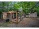An outdoor chicken coop in a wooded area, surrounded by greenery and a secure enclosure for fowl at 1017 Holly Creek Ln, Chapel Hill, NC 27516