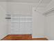 Walk-in closet featuring hardwood floors and white built-in shelving and hanging rods at 1017 Holly Creek Ln, Chapel Hill, NC 27516