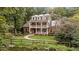 Charming two-story brick home with double balconies and a quaint brick path leading from the pond at 1017 Holly Creek Ln, Chapel Hill, NC 27516