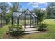 Charming greenhouse with glass walls and a black frame, set in a lush garden, offering a serene space at 1017 Holly Creek Ln, Chapel Hill, NC 27516