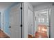 Hallway with hardwood floors leads to a bedroom featuring large windows with plantation shutters at 1017 Holly Creek Ln, Chapel Hill, NC 27516