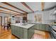 Open-concept kitchen features a large island with seating and views of the dining area and brick fireplace at 1017 Holly Creek Ln, Chapel Hill, NC 27516