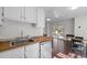 Bright kitchen with butcher block countertops, white cabinets, stainless steel appliances, and access to a rear deck at 1017 Holly Creek Ln, Chapel Hill, NC 27516