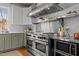 Close up on modern stainless steel stove top and oven surrounded by white backsplash at 1017 Holly Creek Ln, Chapel Hill, NC 27516
