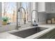 Close up on a black kitchen sink with modern chrome faucets with a window at 1017 Holly Creek Ln, Chapel Hill, NC 27516