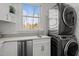 A laundry room with an outside view from the window, a sink, and a stacked washer dryer at 1017 Holly Creek Ln, Chapel Hill, NC 27516