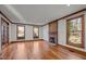 Bright living room with wood floors, brick fireplace, wood trim, and large windows offering scenic views of the outdoors at 1017 Holly Creek Ln, Chapel Hill, NC 27516