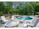 Beautiful backyard pool with waterfall feature, stone surround and comfortable lounge seating, perfect for outdoor relaxation at 1017 Holly Creek Ln, Chapel Hill, NC 27516
