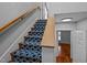 Staircase with blue patterned carpet runner and wooden handrail leads to the upper level at 1017 Holly Creek Ln, Chapel Hill, NC 27516