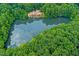 Overhead view of a luxury home surrounded by lush trees and a tranquil lake, offering privacy and natural beauty at 102 Anna Lake Ln, Cary, NC 27513