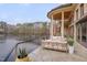The waterfront back patio offers lake views, stone floors, and comfy seating around a lake at 102 Anna Lake Ln, Cary, NC 27513