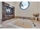 Luxurious bathroom features a soaking tub, fireplace, and a unique round window bringing in plenty of natural light at 102 Anna Lake Ln, Cary, NC 27513