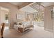 Bright and airy bedroom features a white iron bed frame, a spiral staircase, and a view to the bathroom at 102 Anna Lake Ln, Cary, NC 27513