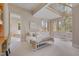 Bright and airy bedroom features a white iron bed frame, a spiral staircase, and a view to the bathroom at 102 Anna Lake Ln, Cary, NC 27513