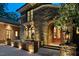Stunning stone house with an arched entryway, fountain, and elegant lighting, creating a welcoming atmosphere at 102 Anna Lake Ln, Cary, NC 27513