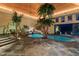 Indoor pool with a waterfall feature, stone accents, and lush greenery for a tropical oasis feel at 102 Anna Lake Ln, Cary, NC 27513