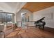 Living area with water views, hardwood floors, grand piano, and stone fireplace at 102 Anna Lake Ln, Cary, NC 27513