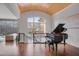 Bright living room with hardwood floors, lake view, piano, and staircase with iron railings at 102 Anna Lake Ln, Cary, NC 27513
