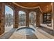 Outdoor spa with stone arches, wood ceilings, and views of the lake, with stone flooring, and a spiral staircase at 102 Anna Lake Ln, Cary, NC 27513